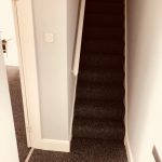 Hallway and stairs with black carpet